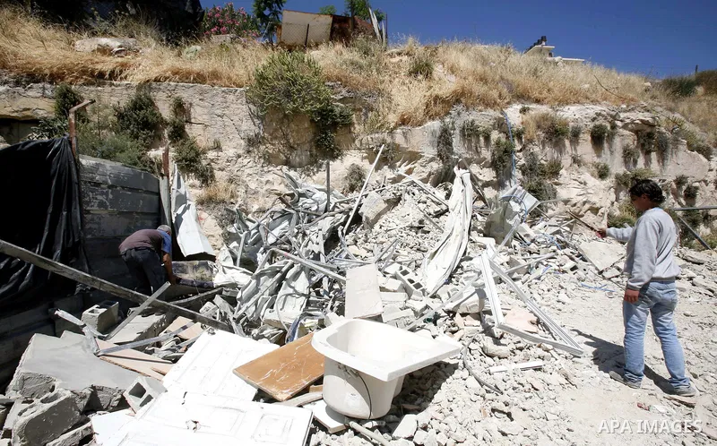 Palestinians survey the damage their house into the Jerusalem's old city on May 20, 2012. Thousands of Israelis marched into Jerusalem's old city to celebrate Jerusalem Day when the Jewish state captured the Arab eastern...