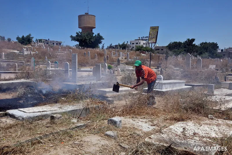 Palestinian prisoners in the prison run by the security forces in Gaza strip, work in a cemetery in Gaza City in activity to save enviroment. On May 21, 2012. Photo by Ali Jadallah