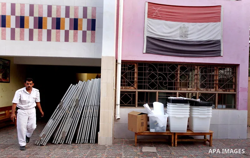 Egyptian policemen stacks notice boards and empty ballot boxes at a polling station in the Coptic neighbourhood of Manshiyet Nasser in Cairo on May 22, 2012. A buzz of excitement swept through the Egyptian capital on the...