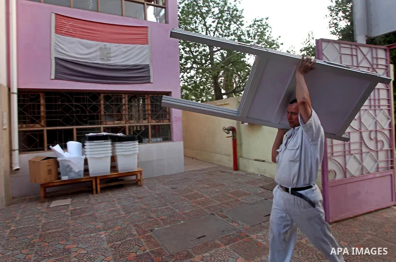 Egyptian policemen stacks notice boards and empty ballot boxes at a polling station in the Coptic neighbourhood of Manshiyet Nasser in Cairo on May 22, 2012. A buzz of excitement swept through the Egyptian capital on the...