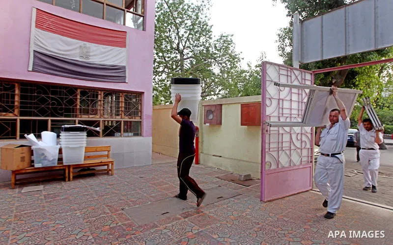 Egyptian policemen stacks notice boards and empty ballot boxes at a polling station in the Coptic neighbourhood of Manshiyet Nasser in Cairo on May 22, 2012. A buzz of excitement swept through the Egyptian capital on the...