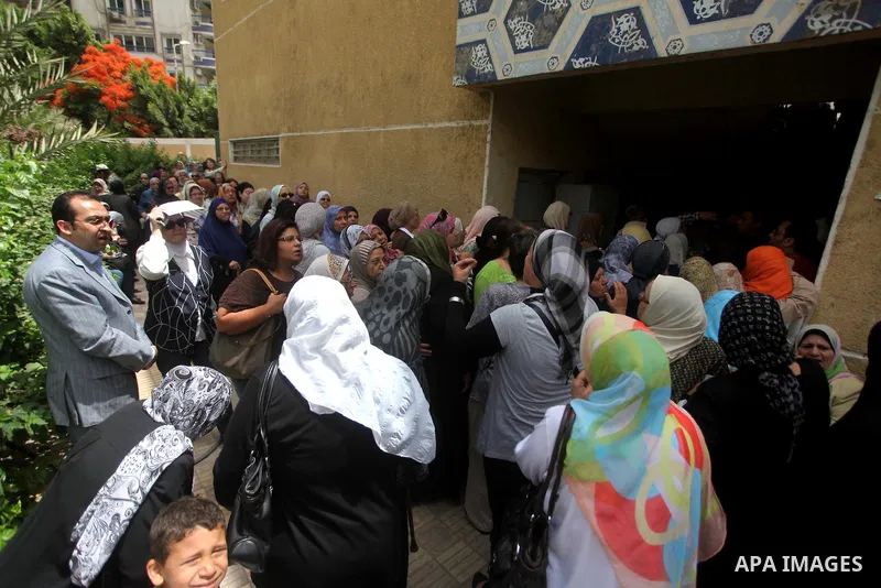 Hundreds of voters line up in front of one of the polling stations to cast their votes on the first day of the presidential elections in Cairo, Egypt, 23 May 2012. Egyptian voters, on 23 May, queued at polling stations f...