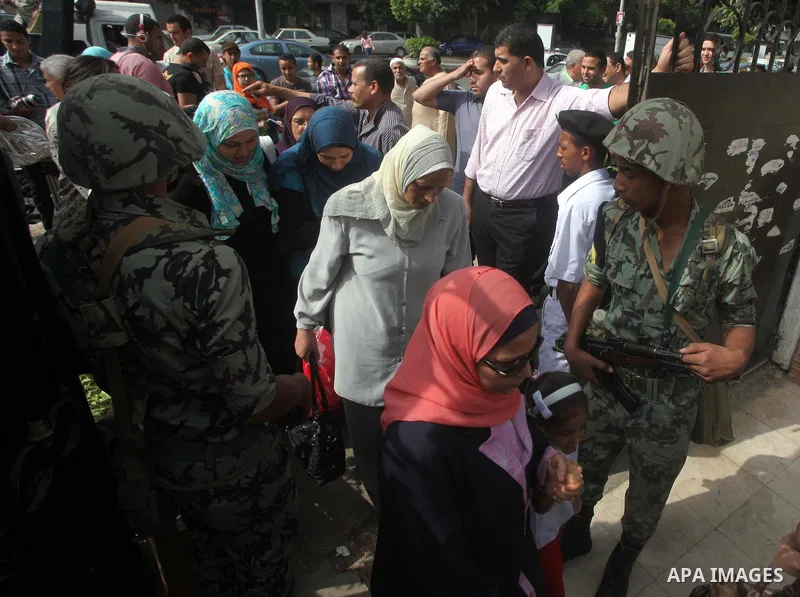 Hundreds of voters line up in front of one of the polling stations to cast their votes on the first day of the presidential elections in Cairo, Egypt, 23 May 2012. Egyptian voters, on 23 May, queued at polling stations f...