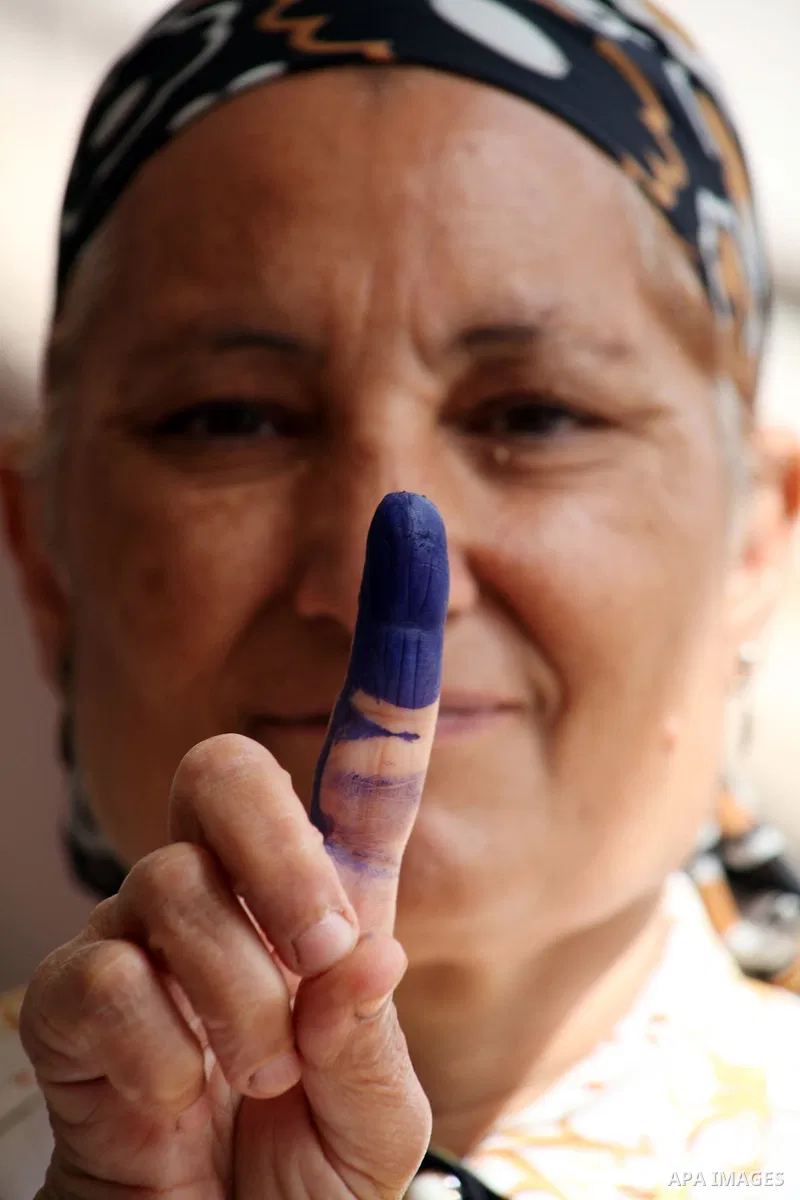 Egyptian woman shows her ink-marked finger after casting her ballot during the first round of Egypt's presidential elections, at a polling station in Cairo, Egypt, 23 May 2012. Egyptian voters, on 23 May, queued at polli...