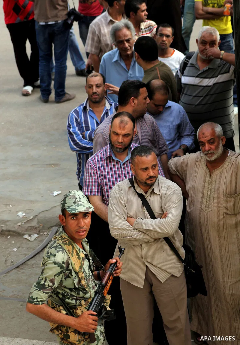 Hundreds of voters line up in front of one of the polling stations to cast their votes on the first day of the presidential elections in Cairo, Egypt, 23 May 2012. Egyptian voters, on 23 May, queued at polling stations f...