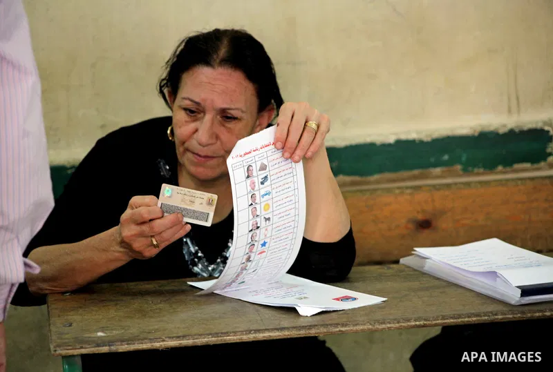 An Egyptian election observer checks a voter ID on the first day of the presidential elections in Cairo, Egypt, 23 May 2012. Egyptian voters, on 23 May, queued at polling stations for the first Presidential election sinc...
