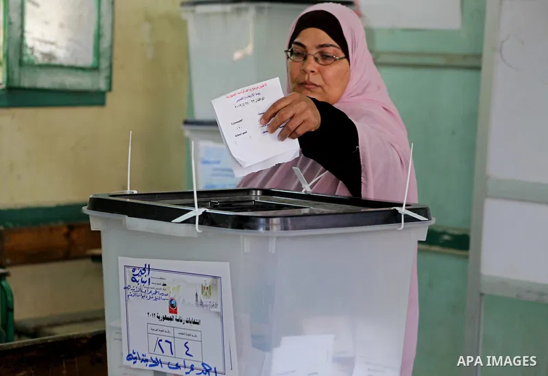 An Egyptian voter casts her ballots at one of the polling stations, on the first day of the presidential elections in Cairo, Egypt, 23 May 2012. Egyptian voters, on 23 May, queued at polling stations for the first Presid...