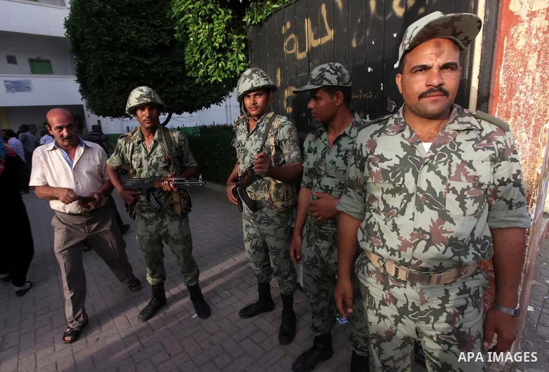 Egyptian security gards, stand in the front of one of the polling stations, on the first day of the presidential elections in Cairo, Egypt, 23 May 2012. Egyptian voters, on 23 May, queued at polling stations for the firs...