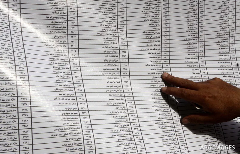 An Egyptian voter searches for his name outside a polling station to cast their votes on the first day of the presidential elections in Cairo, Egypt, 23 May 2012. Egyptian voters, on 23 May, queued at polling stations fo...