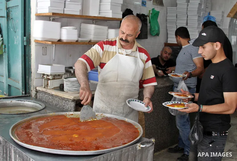 Palestinians buy the Nabulsi Kunafa, a traditional and favorite local sweet, in the West Bank, city of nablus on May 24, 2012. Photo by Nedal Eshtayah .