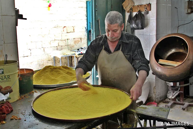 Palestinian baker prepares Nabulsi Kunafa, a traditional and favorite local sweet, in the West Bank, city of nablus on May 24, 2012. Photo by Nedal Eshtayah .