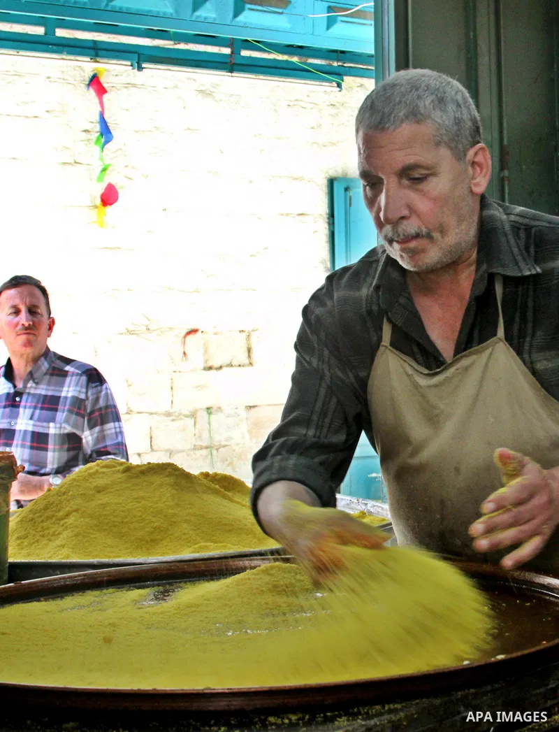 Palestinian baker prepares Nabulsi Kunafa, a traditional and favorite local sweet, in the West Bank, city of nablus on May 24, 2012. Photo by Nedal Eshtayah .