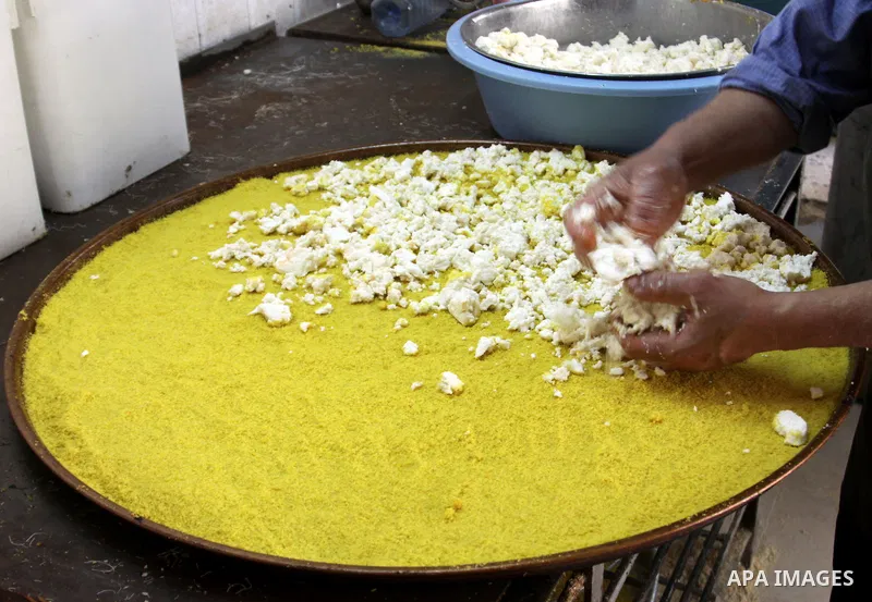 Palestinian baker prepares Nabulsi Kunafa, a traditional and favorite local sweet, in the West Bank, city of nablus on May 24, 2012. Photo by Nedal Eshtayah .