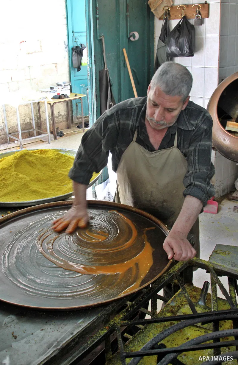 Palestinian baker prepares Nabulsi Kunafa, a traditional and favorite local sweet, in the West Bank, city of nablus on May 24, 2012. Photo by Nedal Eshtayah .