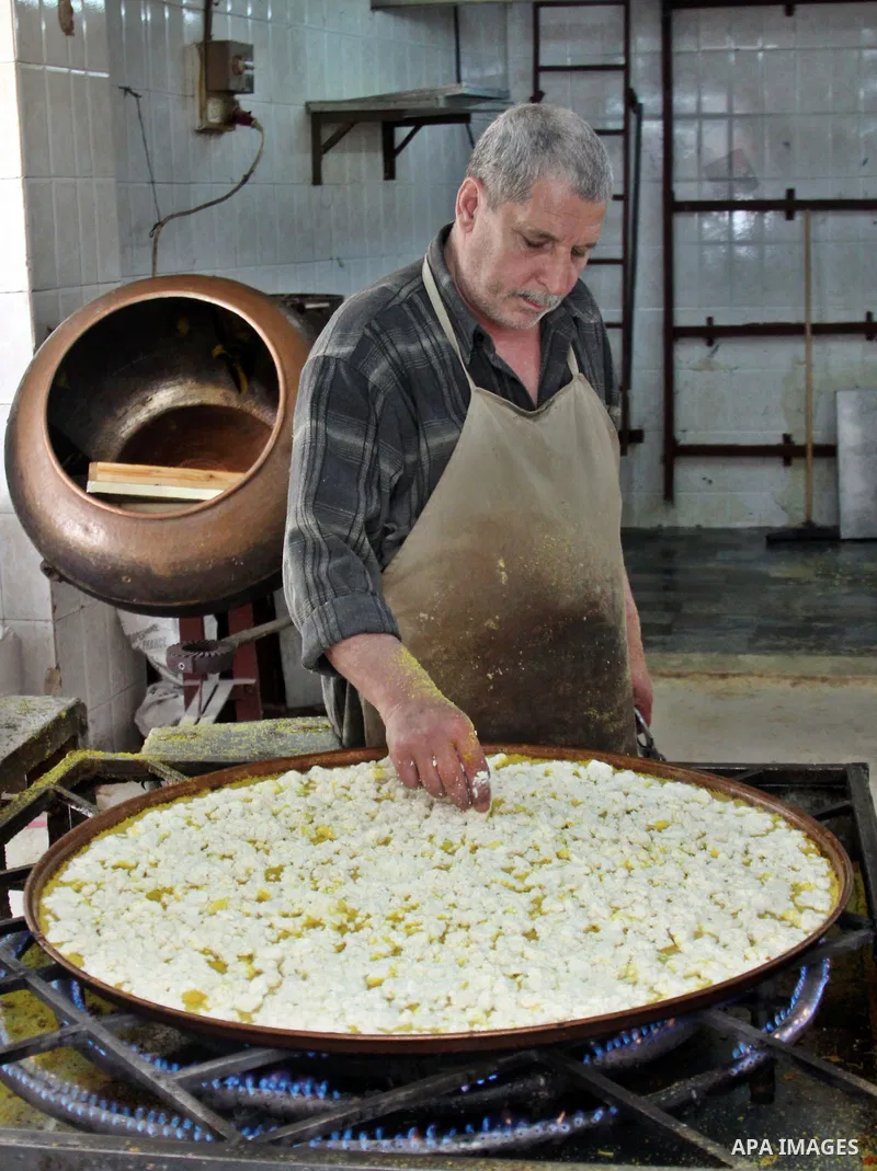 Palestinian baker prepares Nabulsi Kunafa, a traditional and favorite local sweet, in the West Bank, city of nablus on May 24, 2012. Photo by Nedal Eshtayah .
