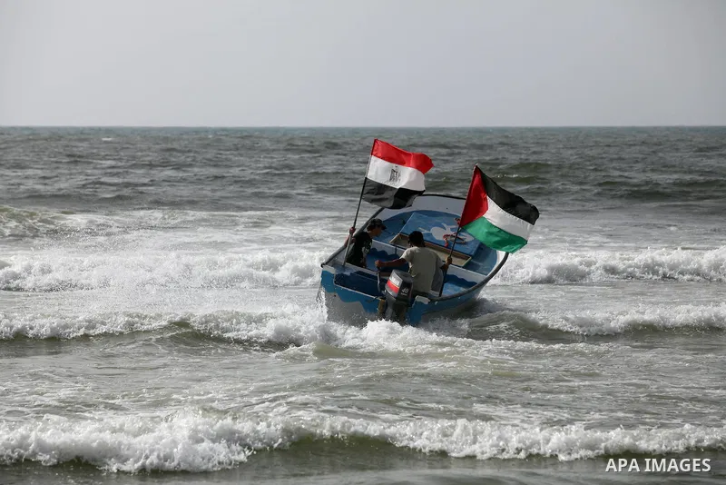 Palestinian holds a Palestinian and Egyptian flags on his boat at the beach of Gaza city on 24 May 2012, in the first Egyptian Presidential election since the ouster of former president Hosni Mubarak in February 2011. Ph...