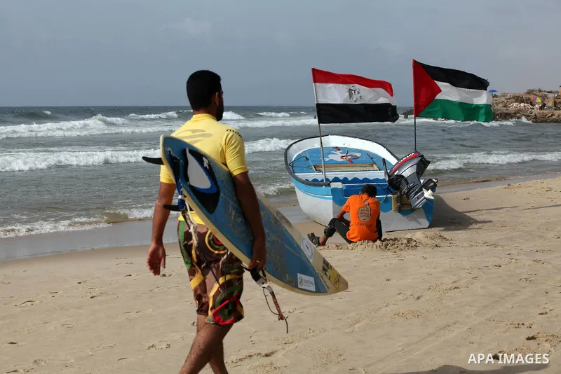 Palestinian holds a Palestinian and Egyptian flags on his boat at the beach of Gaza city on 24 May 2012, in the first Egyptian Presidential election since the ouster of former president Hosni Mubarak in February 2011. Ph...