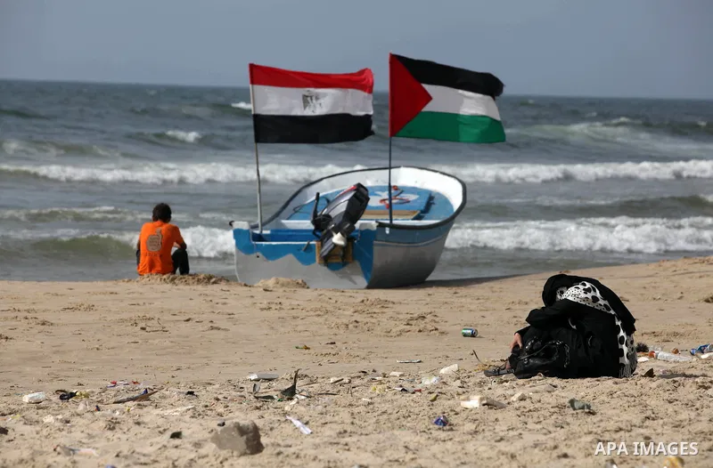 Palestinian holds a Palestinian and Egyptian flags on his boat at the beach of Gaza city on 24 May 2012, in the first Egyptian Presidential election since the ouster of former president Hosni Mubarak in February 2011. Ph...