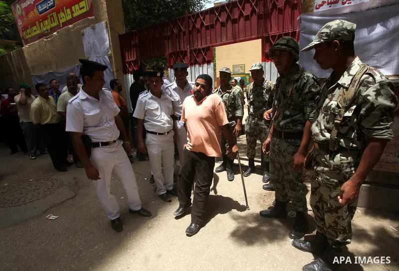 Egyptian policemen help a handicapped man to vote during second day of the first round of Egypt's presidential elections in Cairo, Egypt, 24 May 2012. Media reports quoting state-television and observers said that far le...