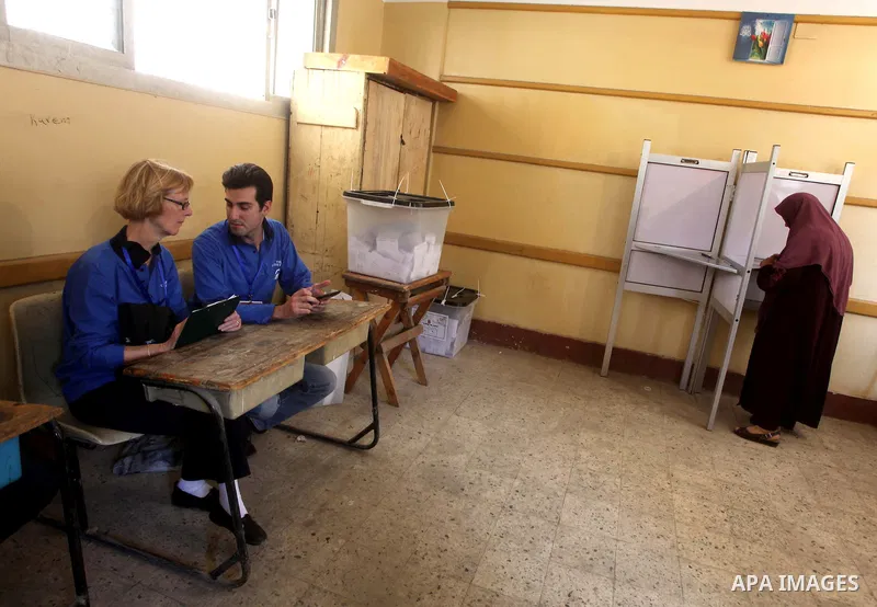 Egyptian voters cast their ballots presence of international observers at one of the polling stations during the first round of Egypt's presidential elections, at a polling station in Cairo, Egypt, 24 May 2012. for the f...