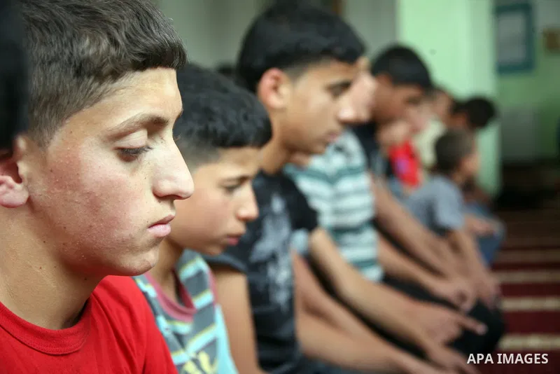 Palestinian orphan children pray at the Hebron's orphan house, in the West Bank city of Hebron 24 May 2012. Hebron's orphan house contain about 100 orphan children from ages 6 to 18 years old, and oversees some of orphan...