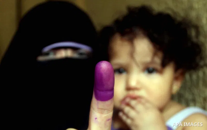 An Egyptian woman shows her ink-marked finger after casting her ballot during the first round of Egypt's presidential elections, at a polling station in Cairo, Egypt, 24 May 2012. for the first Presidential election sinc...