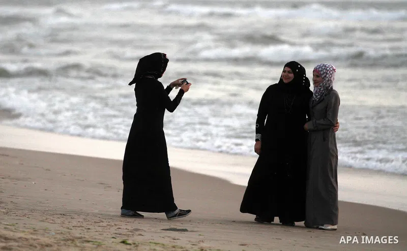 Palestinian girls take a photo on the beach of Gaza City on May 24, 2012. Gaza beach is the only outlet for the Palestinians after tightening the Israeli blockade on the Gaza Strip. Photo by Majdi Fathi