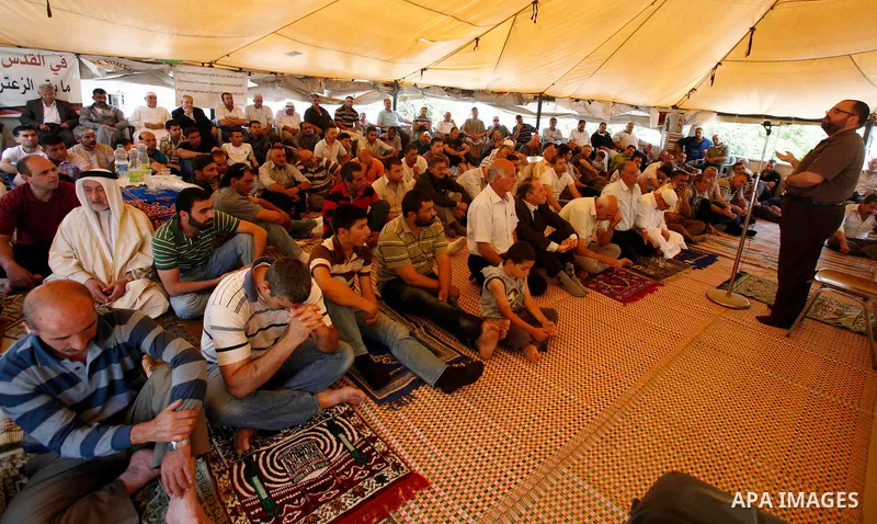 Palestinian Muslim worshippers attend Friday prayers inside a protest tent against the continuing 'Judaization of Jerusalem' by Jewish settlers, in the mostly Arab neighbourhood of Silwan in east Jerusalem on May 25, 201...