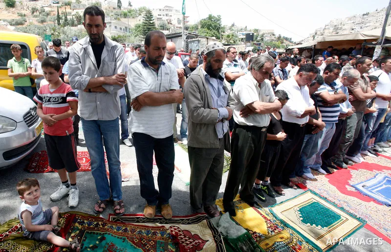 Palestinian Muslim worshippers attend Friday prayers outside a protest tent against the continuing 'Judaization of Jerusalem' by Jewish settlers, in the mostly Arab neighbourhood of Silwan in east Jerusalem on May 25, 20...