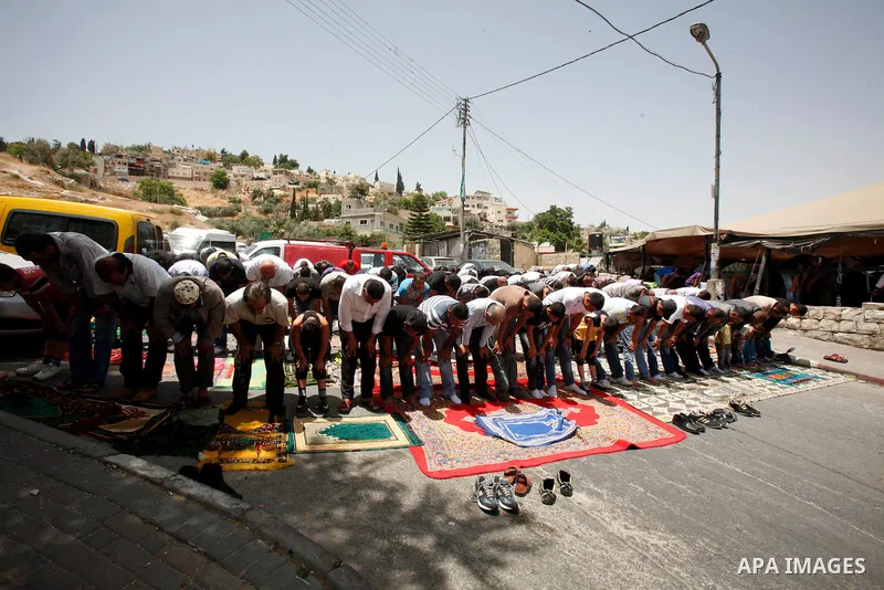 Palestinian Muslim worshippers attend Friday prayers outside a protest tent against the continuing 'Judaization of Jerusalem' by Jewish settlers, in the mostly Arab neighbourhood of Silwan in east Jerusalem on May 25, 20...
