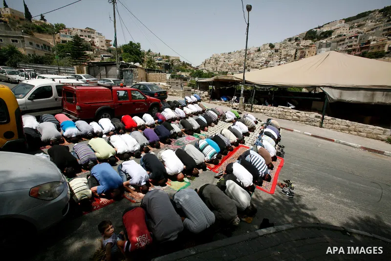 Palestinian Muslim worshippers attend Friday prayers outside a protest tent against the continuing 'Judaization of Jerusalem' by Jewish settlers, in the mostly Arab neighbourhood of Silwan in east Jerusalem on May 25, 20...