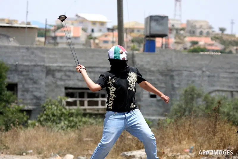 A Palestinian protester throws stone at Israeli soldiers during clashes in the northern West Bank village of Kufr Qaddum, near the Jewish settlement of Kdumim, on May 25, 2012. Photo by Wagdi Eshtayah