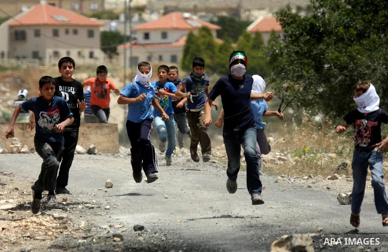 Palestinian protesters throw stones at Israeli soldiers during clashes in the northern West Bank village of Kufr Qaddum, near the Jewish settlement of Kdumim, on May 25, 2012. Photo by Wagdi Eshtayah