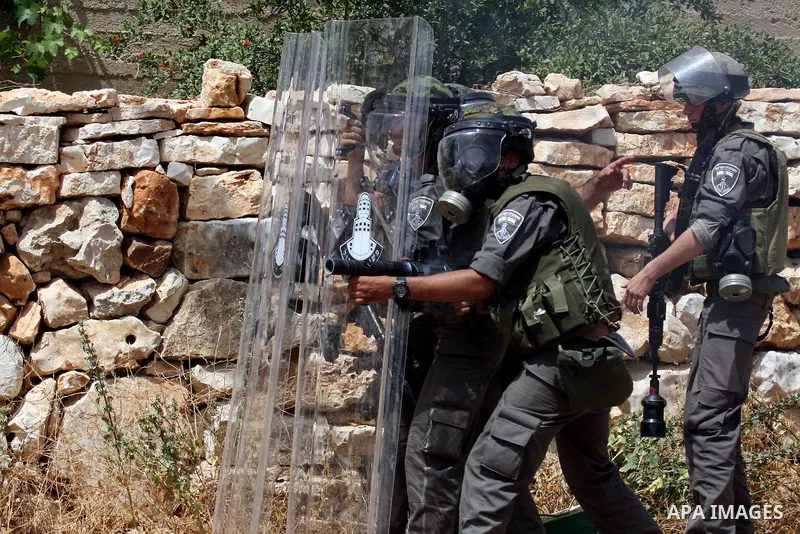 An Israeli soldier fires tear gas at Palestinian protesters during clashes in the northern West Bank village of Kufr Qaddum, near the Jewish settlement of Kdumim, on May 25, 2012. Photo by Wagdi Eshtayah