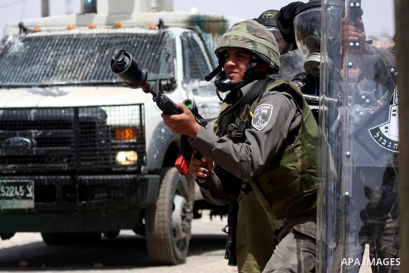 An Israeli soldier fires tear gas at Palestinian protesters during clashes in the northern West Bank village of Kufr Qaddum, near the Jewish settlement of Kdumim, on May 25, 2012. Photo by Wagdi Eshtayah