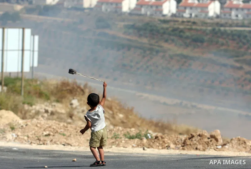 A Palestinian child holds a sling shot during clashes between stone throwers and Israeli soldiers in the West Bank village of Nabi Saleh, near Ramallah, on May 25, 2012 following a protest against the confiscation of Pal...