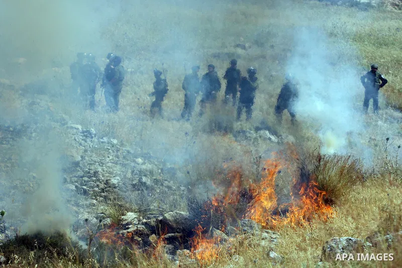 Israeli soldiers fire tear gas at Palestinian protesters during clashes between stone throwers and Israeli soldiers in the West Bank village of Nabi Saleh, near Ramallah, on May 25, 2012 following a protest against the c...