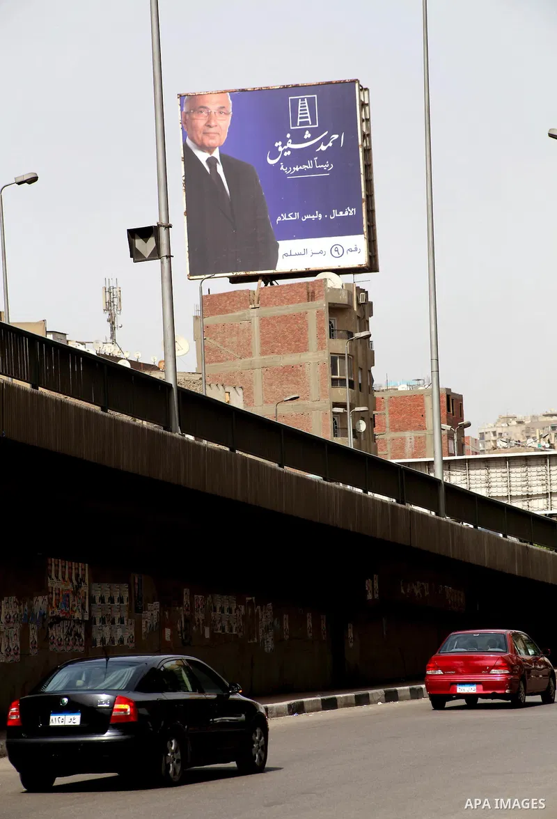 A defaced billboard of Egyptian presidential candidate Ahmed Shafiq stands in a street in Cairo May 25, 2012. Egypt looked set for a run-off presidential vote pitting Muslim Brotherhood candidate Mohammed Mursi against M...