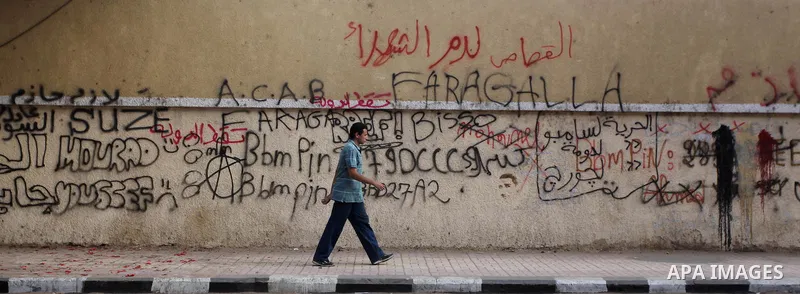 Egyptians walk under a banner of the Muslim Brotherhood's presidential candidate Mohammed Mursi in Cairo on May 25, 2012. Egypt looked set for a run-off presidential vote pitting Mursi against Mubarak-era minister Ahmed...