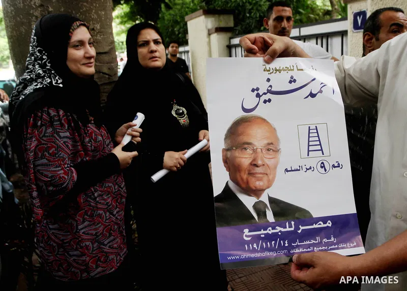 A supporter of Egyptian presidential candidate and former prime minister Ahmed Shafiq holds his poster during a press conference in Cairo on May 26, 2012. Shafiq, ousted leader Hosni Mubarak's ex-premier who is set to fa...