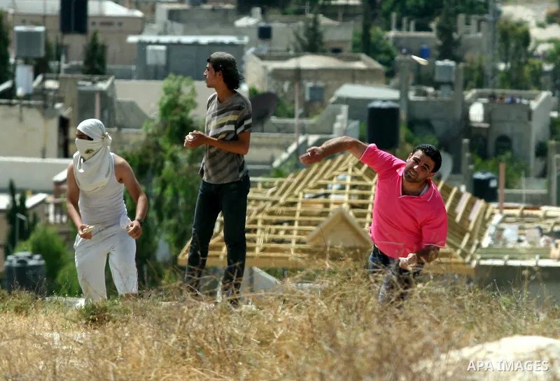 Palestinian Youths throw stones at Israeli soldiers after burnt agriculture fields by Jewish settlers in Oref village near the west bank city of Nablus. on May 26.2012. Photo by Nedal Shtieh.