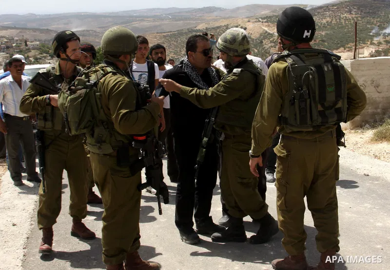 Palestinian protesters run for cover as Israeli forces fire in the air to disperse the crowd during clashes that followed the setting on fire of fields of grain and olive trees by hardline settlers from the Jewish settle...