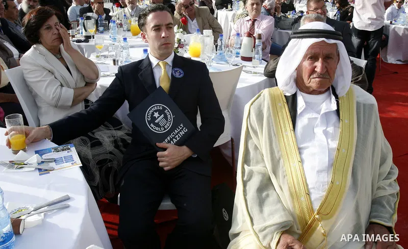 Palestinians participate a celebration in Arab east jerusalem after the longest buffet of natural and organic food registered a new Guinness world record. -- Palestinians serve food from the longest buffet table of natur...