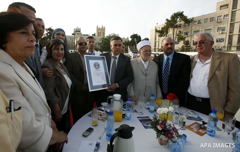 British Jack Brockbank , an international adjudicator from Guinness World Records, presents a certificate to Palestinian Prime Minister Salam Fayad for the longest buffet of natural and organic food setting a new guinnes...