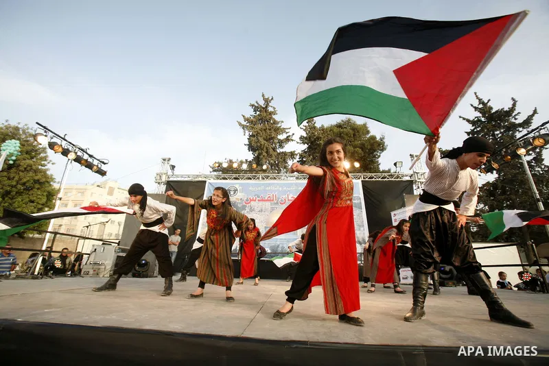 A Palestinian folkloric dance troupe performs during a celebration in Arab east jerusalem after the longest buffet of natural and organic food registered a new Guinness world record, on May 26, 2012 in Arab east jerusale...