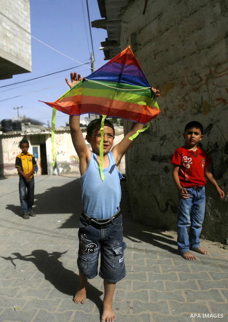 A Palestinian boy refugee flies kite at the street during the summer holiday in the Rafah refugee camp southern Gaza Strip on May 29, 2012. Photo by Eyad Al Baba