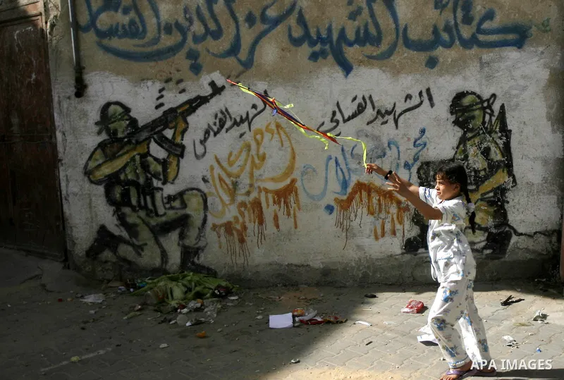 A Palestinian girl refugee flies kite at the street during the summer holiday in the Rafah refugee camp southern Gaza Strip on May 29, 2012. Photo by Eyad Al Baba