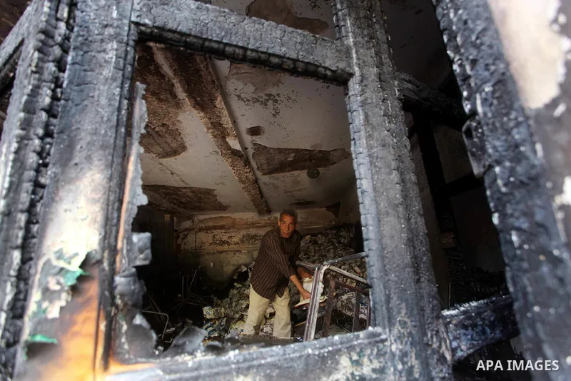 A man checks the scene inside the burnt campaign headquarters of candidate and former prime minister Ahmed Shafiq in Cairo May 29, 2012. A group of Egyptian protesters set fire to the headquarters on Monday, the state ne...