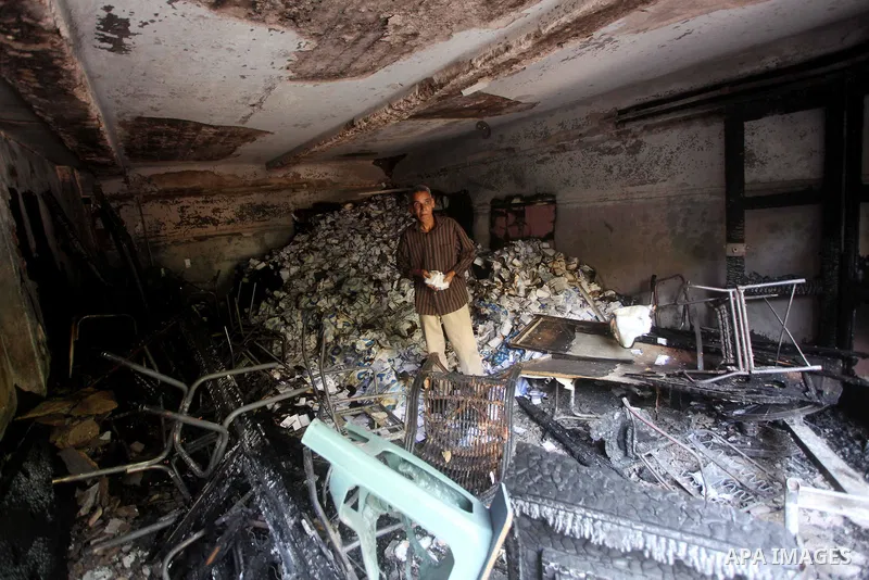 A man checks the scene inside the burnt campaign headquarters of candidate and former prime minister Ahmed Shafiq in Cairo May 29, 2012. A group of Egyptian protesters set fire to the headquarters on Monday, the state ne...