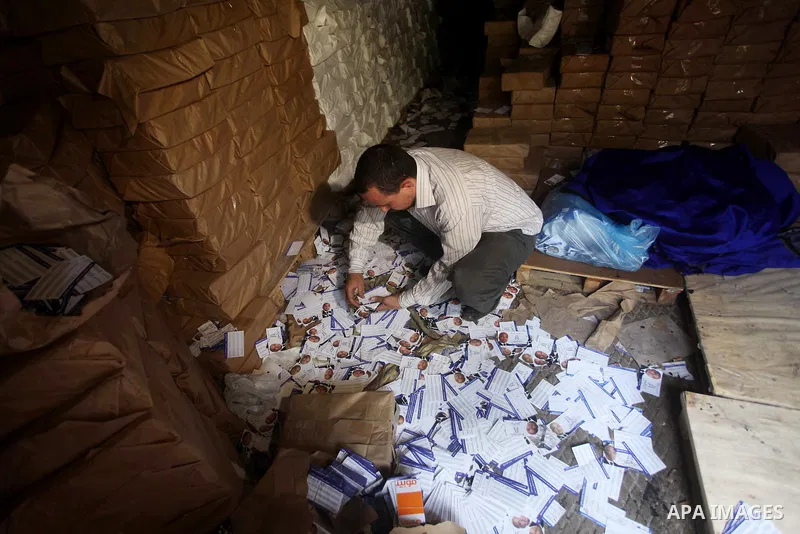 A man shows flyers of presidential candidate Ahmed Shafiq at the scene of the burnt campaign headquarters of Shafiq in Cairo May 29, 2012. A group of Egyptian protesters set fire to the headquarters on Monday, the state...